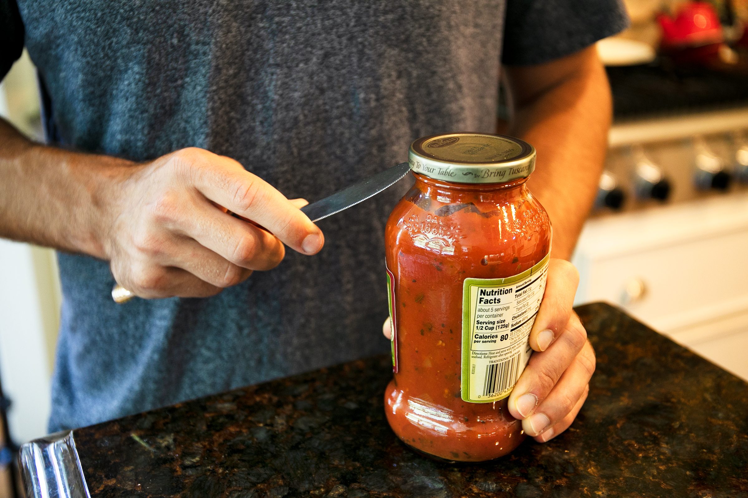 man opening jar with a butter knife
