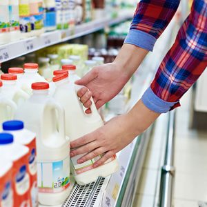 Woman shopping milk in grocery store