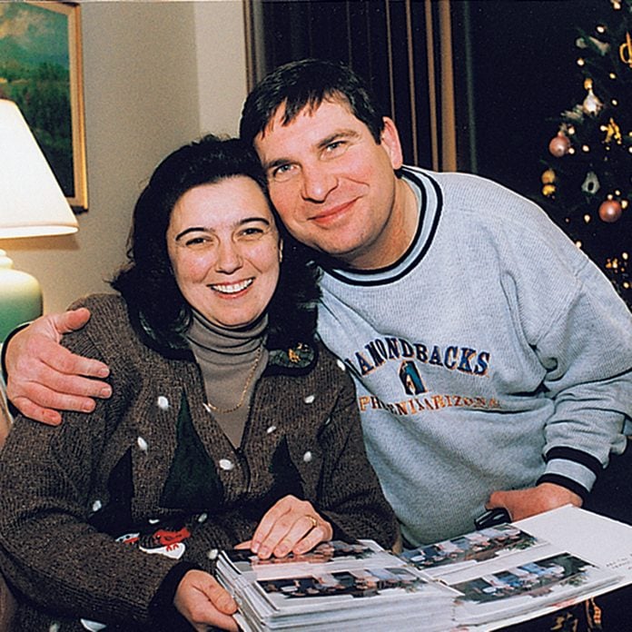 Man and woman hugging over a photo book of Christmas memories