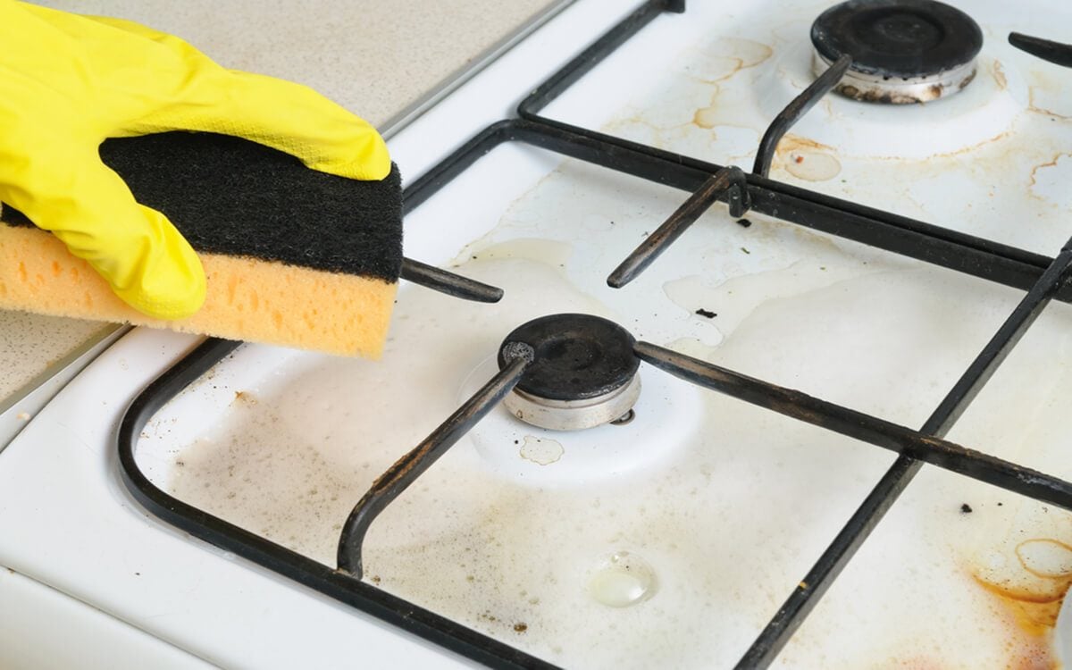 cleaning of dirty gas stove burners in kitchen room