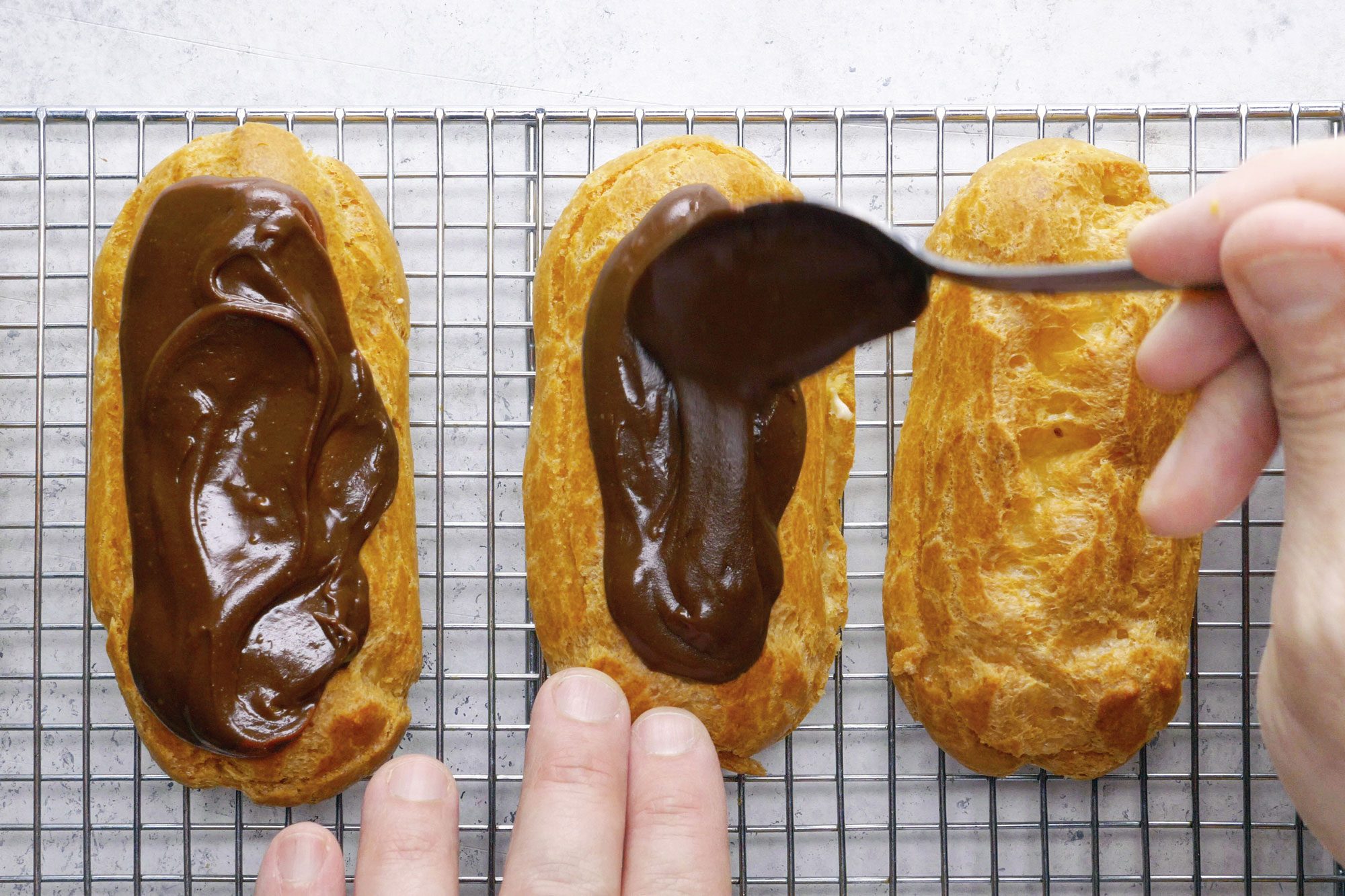 Chocolate Eclairs frosting the eclairs