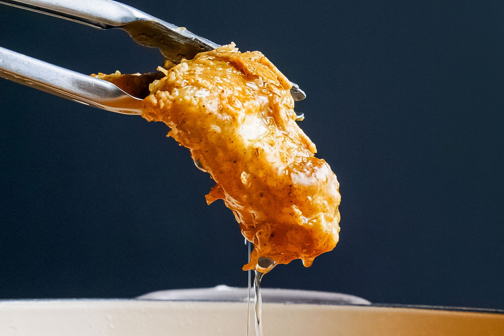 Crispy Fried Chicken Picked with Cooking Tong