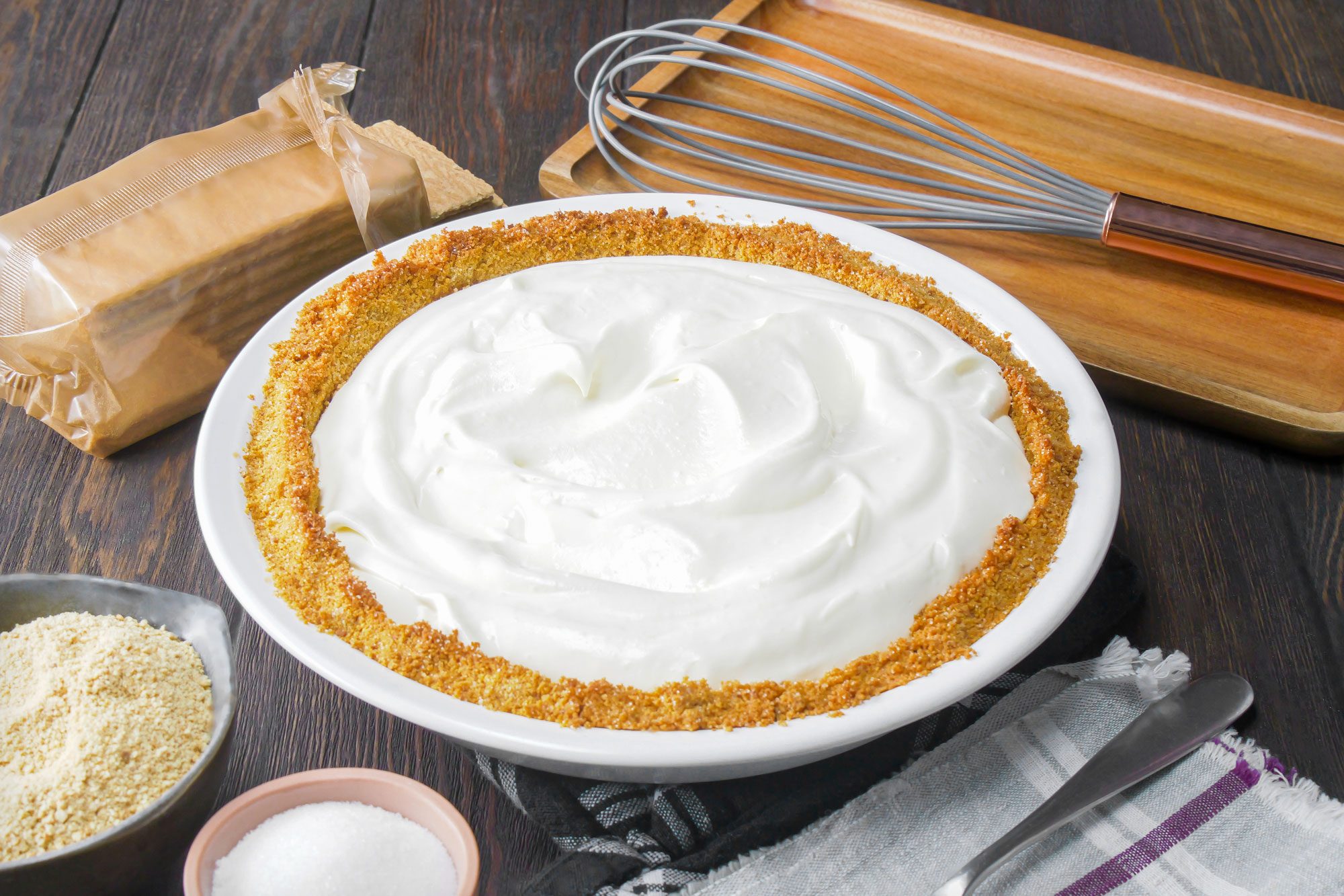 Graham Cracker Cream Pie in White Ceramic Pie Plate on Wooden Surface