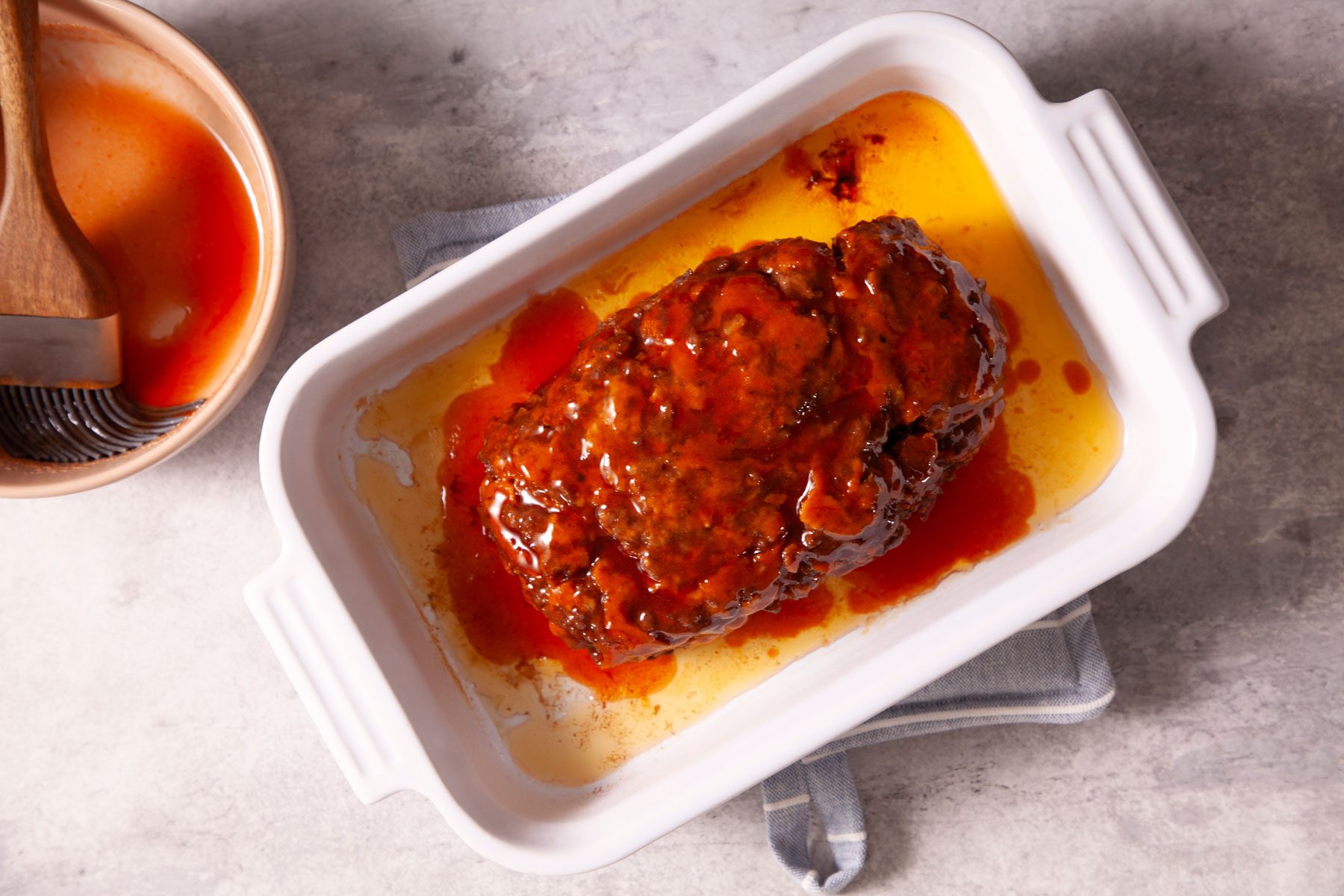A Meat Loaf in a White Dish With Sauce
