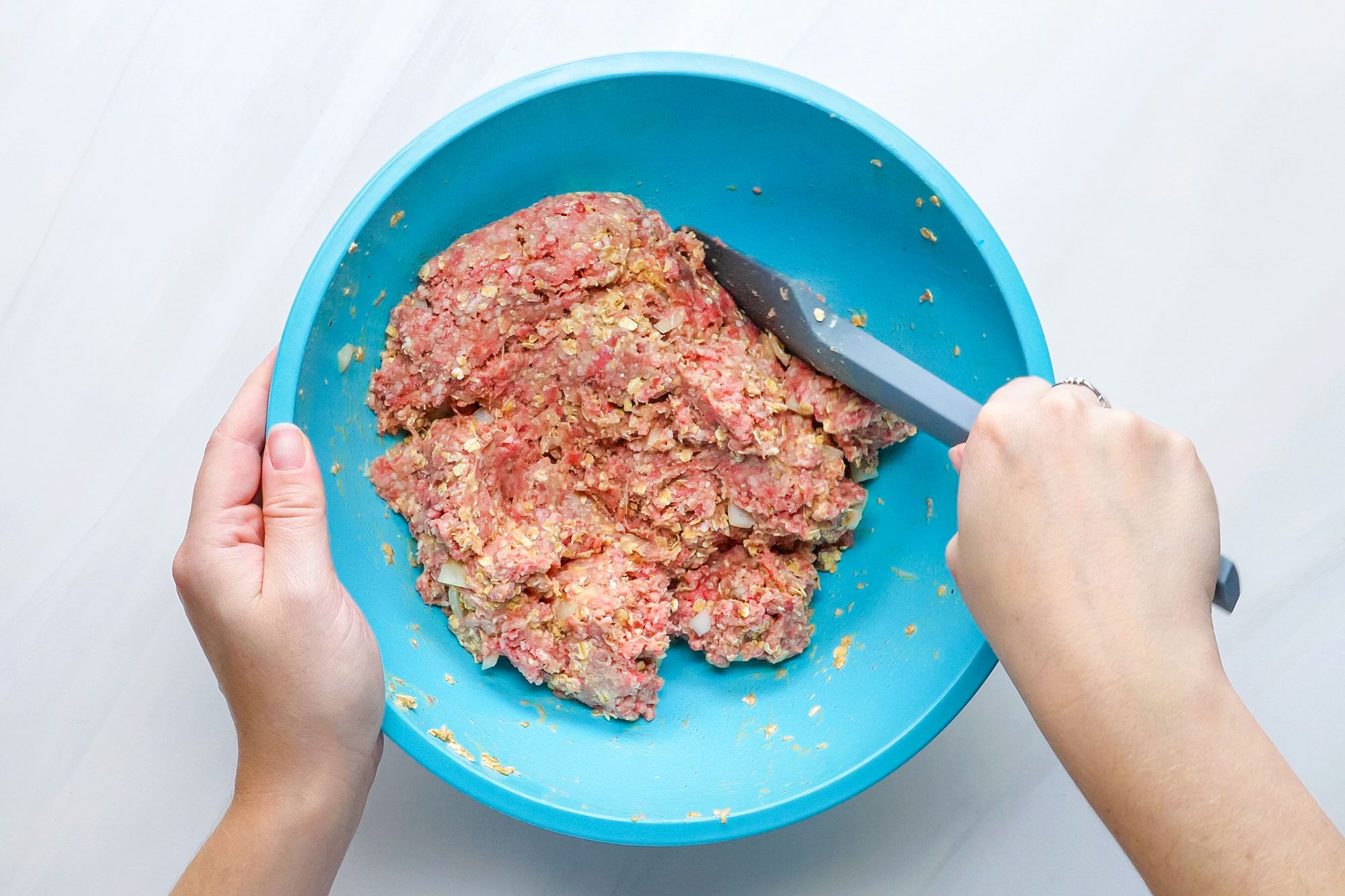 Mixing Beef with Other Ingredients in a Large Bowl to make Meat Loaf