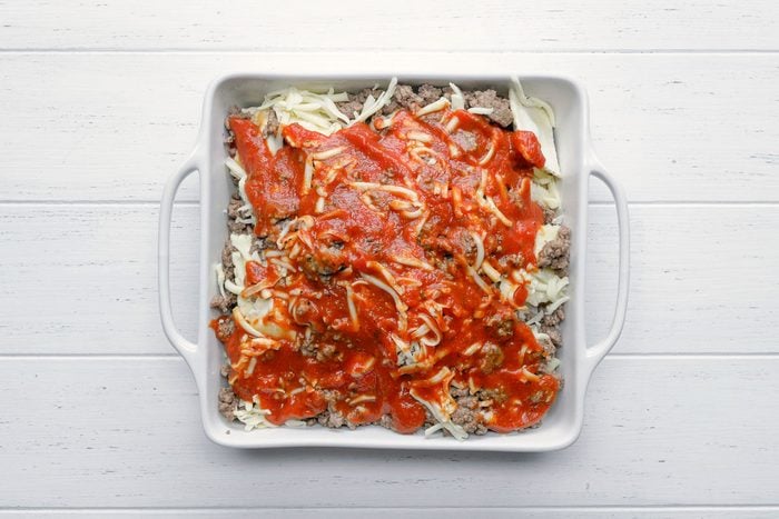 the top layer of the lasagna topped with sauce and cheese