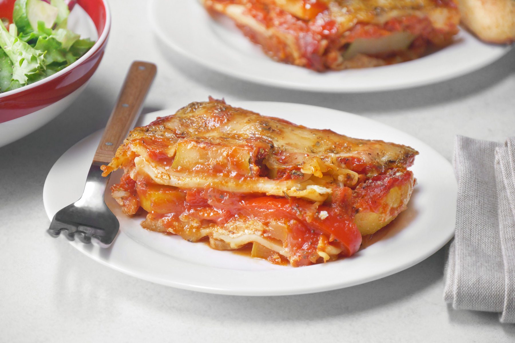 A plate of lasagna with a salad on it