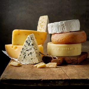 various types of cheese on rustic wooden table