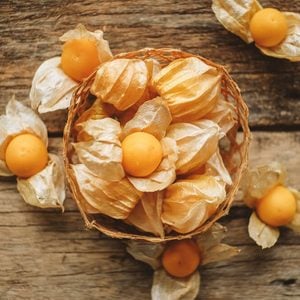 Husk tomato and Ground Cherry in basket on wood table background.