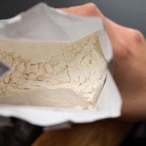 Top View Of Hand Holding Open Bag Of Flour