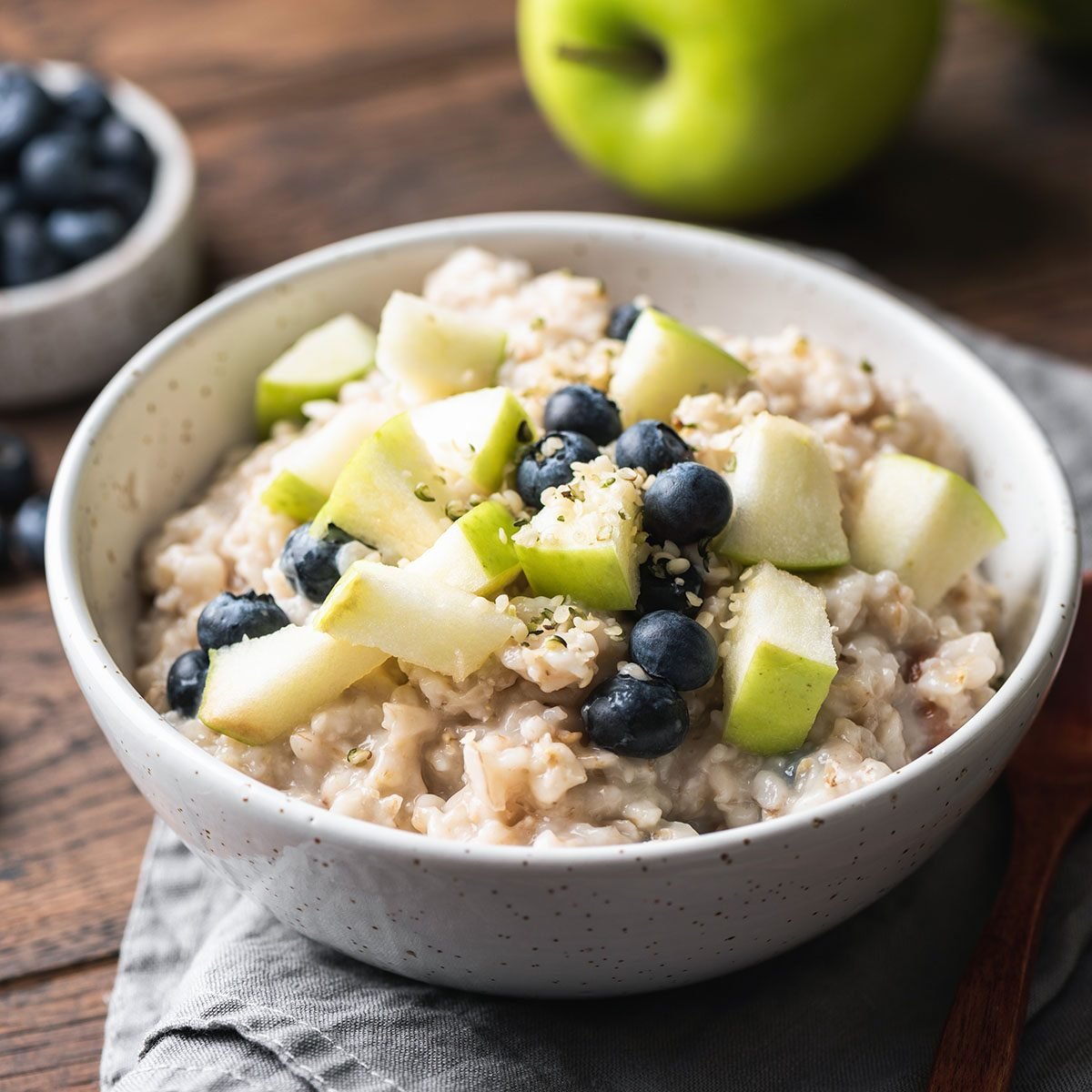 Oatmeal porridge with green apple, hemp seeds and blueberries