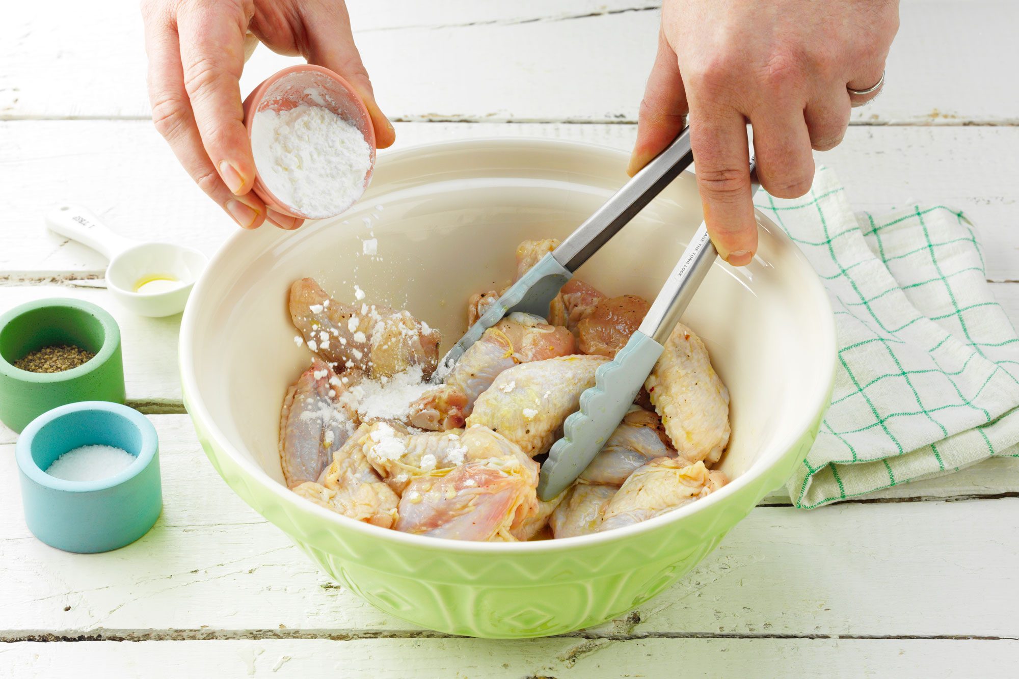 prepping the chicken wings in a large bowl tossed in cornstarch salt and pepper for grilled chicken wings