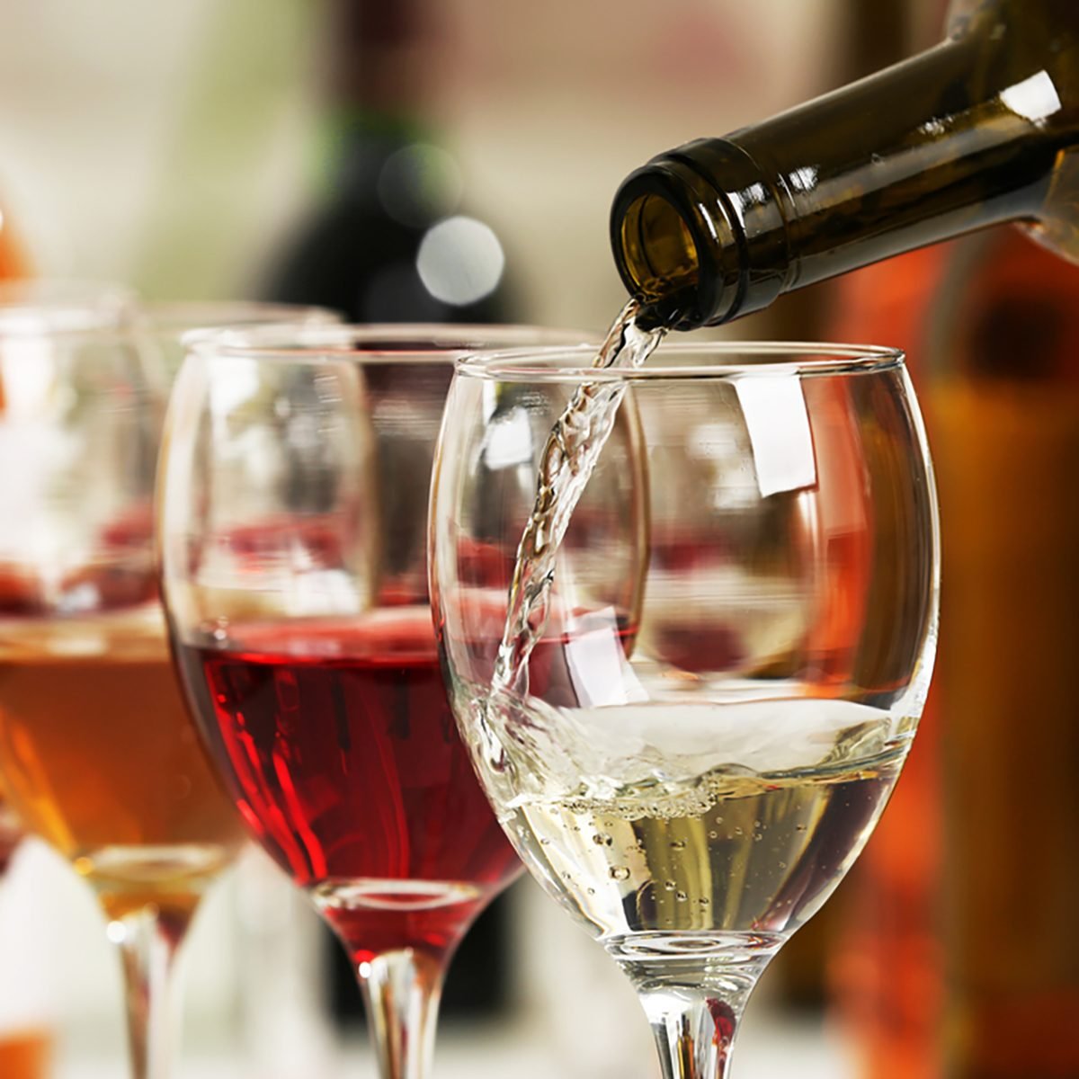 White wine pouring into glasses, closeup