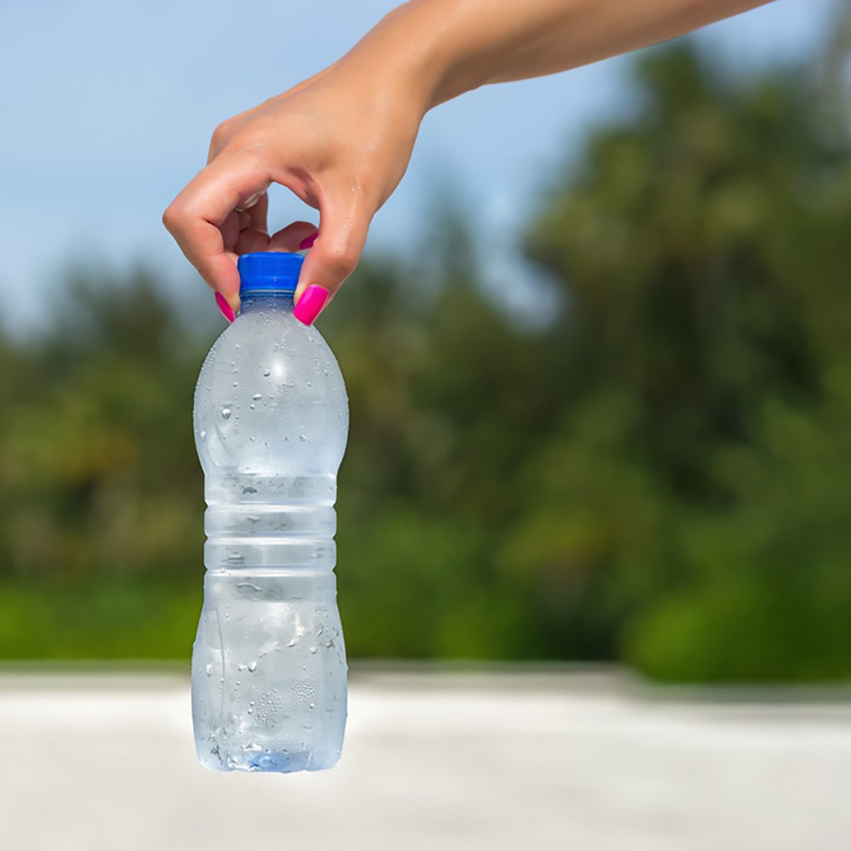Woman hand holding water bottle outdoors
