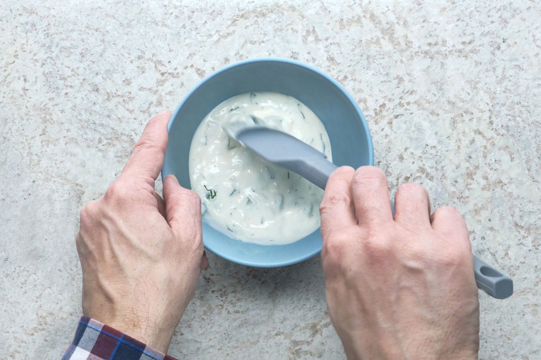 Yogurt, mayonnaise, cucumber mixed in a bowl