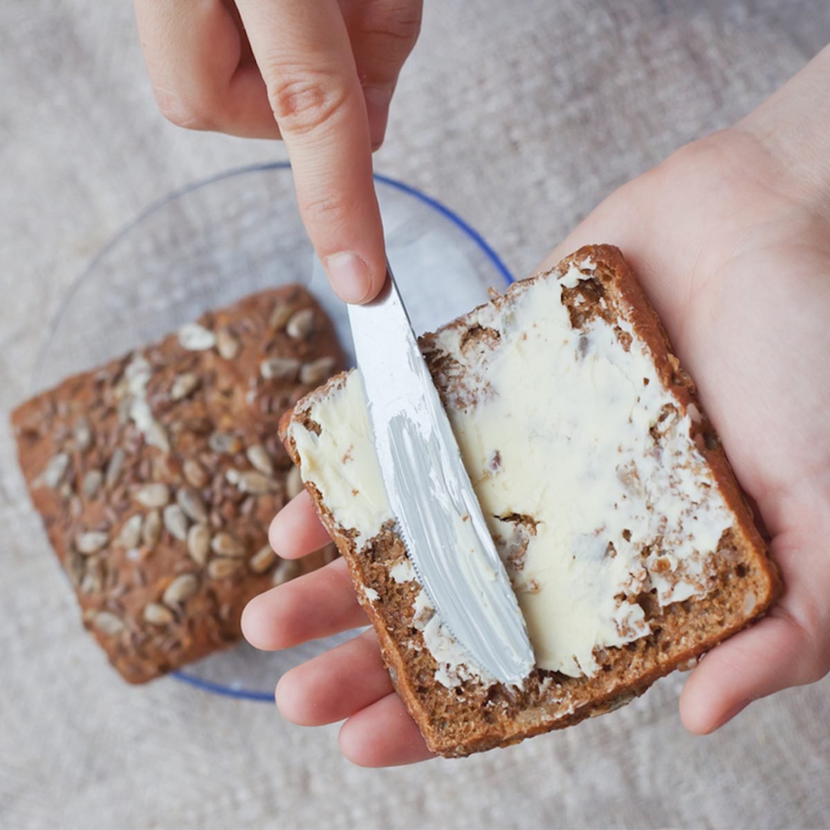 spreading butter on a slice of bread