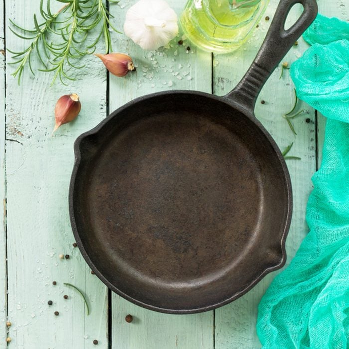 Cast-iron frying pan, fresh rosemary, garlic, olive oil and spices.