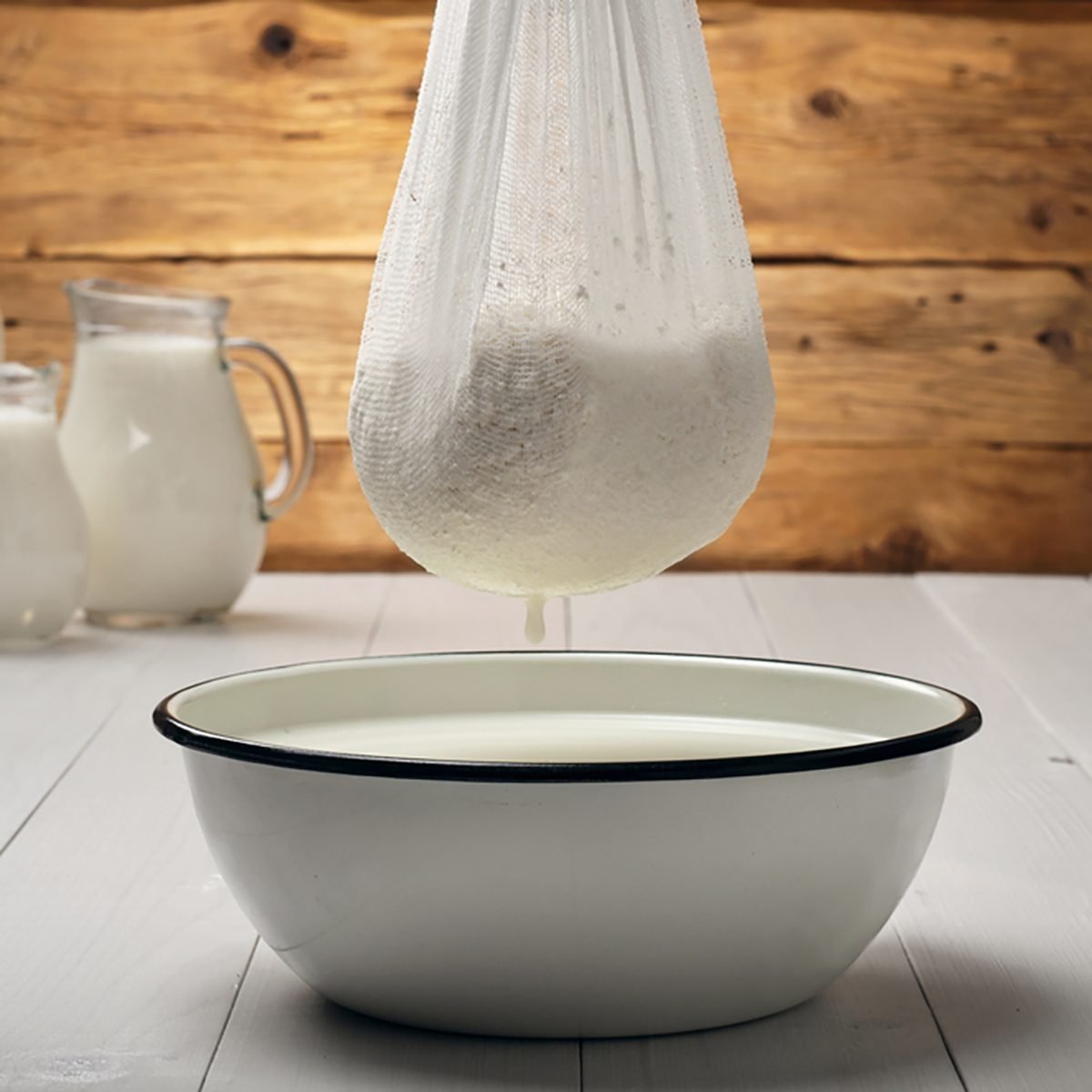 Cooking homemade cottage cheese on a wooden background.