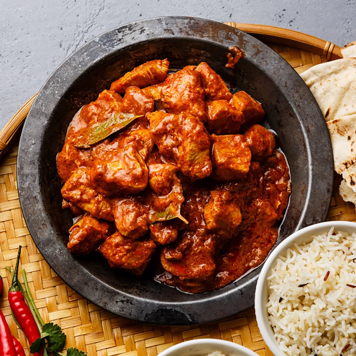Chicken tikka masala spicy curry meat food in metal plate, rice and naan bread close-up