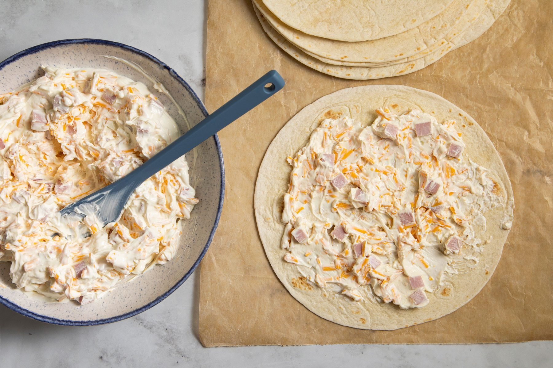 Ham And Cheese filling spread over the tortillas