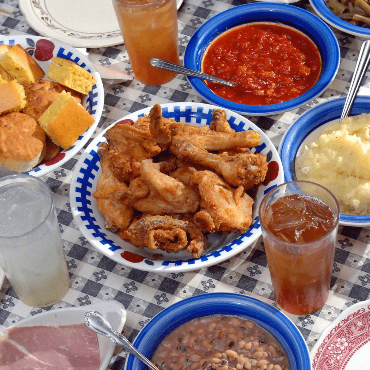 Tanglewood fried chicken with bowls of rolls, sauces and mashed potatoes nearby