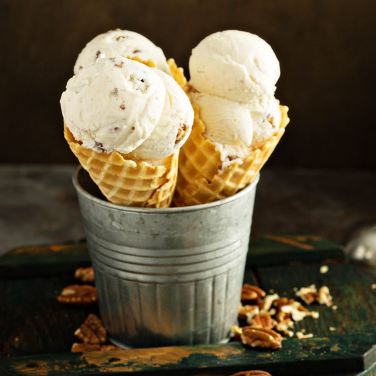Butter pecan ice cream in waffle cones on dark background; Shutterstock ID 1110602510; Job (TFH, TOH, RD, BNB, CWM, CM): Taste of Home