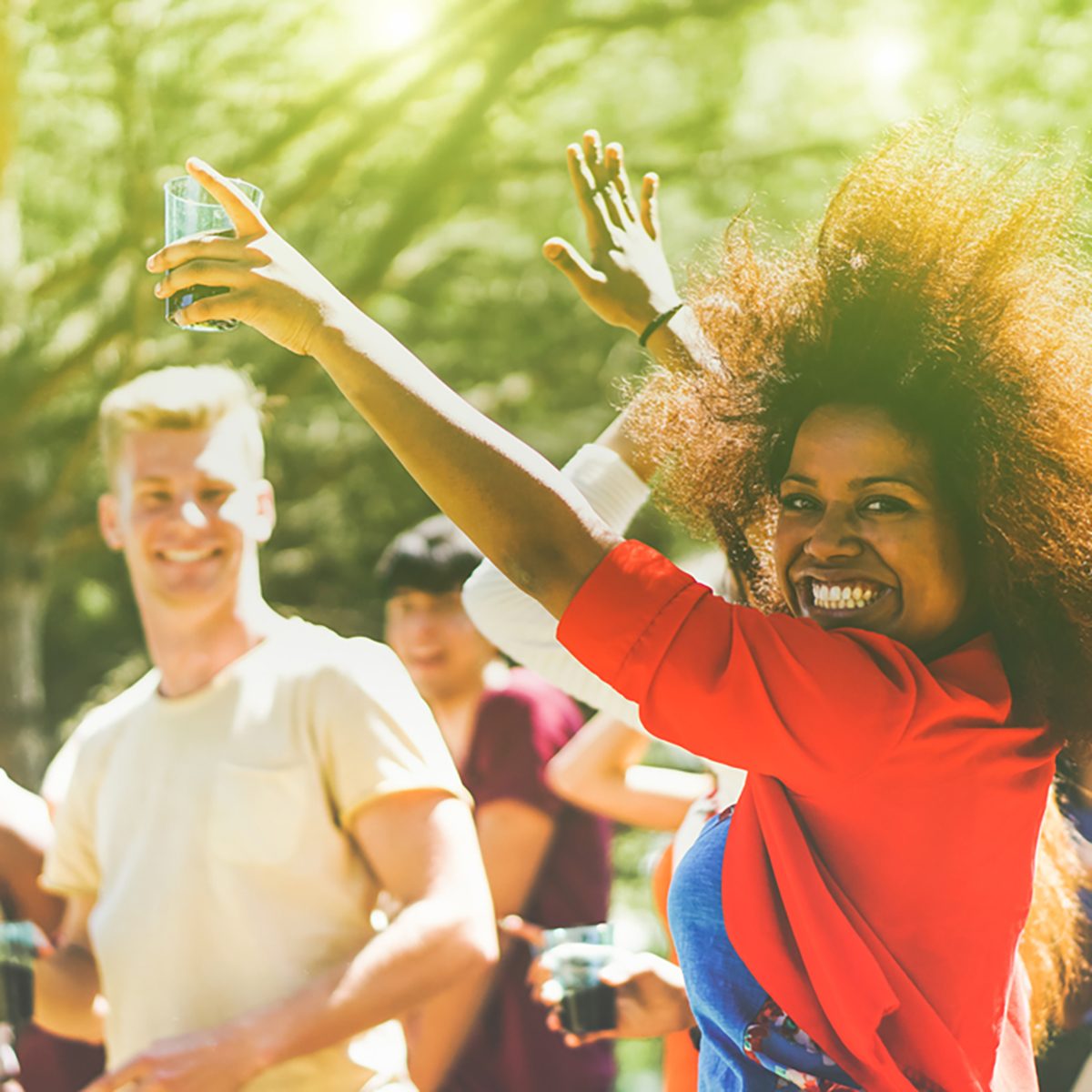 Multiracial young people dancing in forest party in summer time 