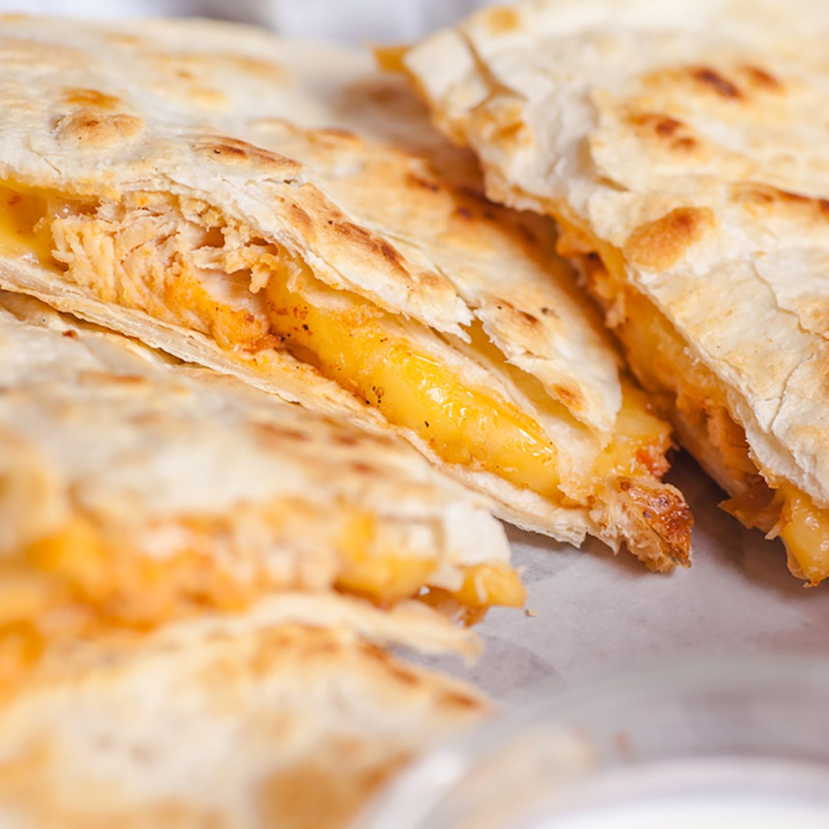 Close up shot of several freshly served cheese quesadillas on a platter