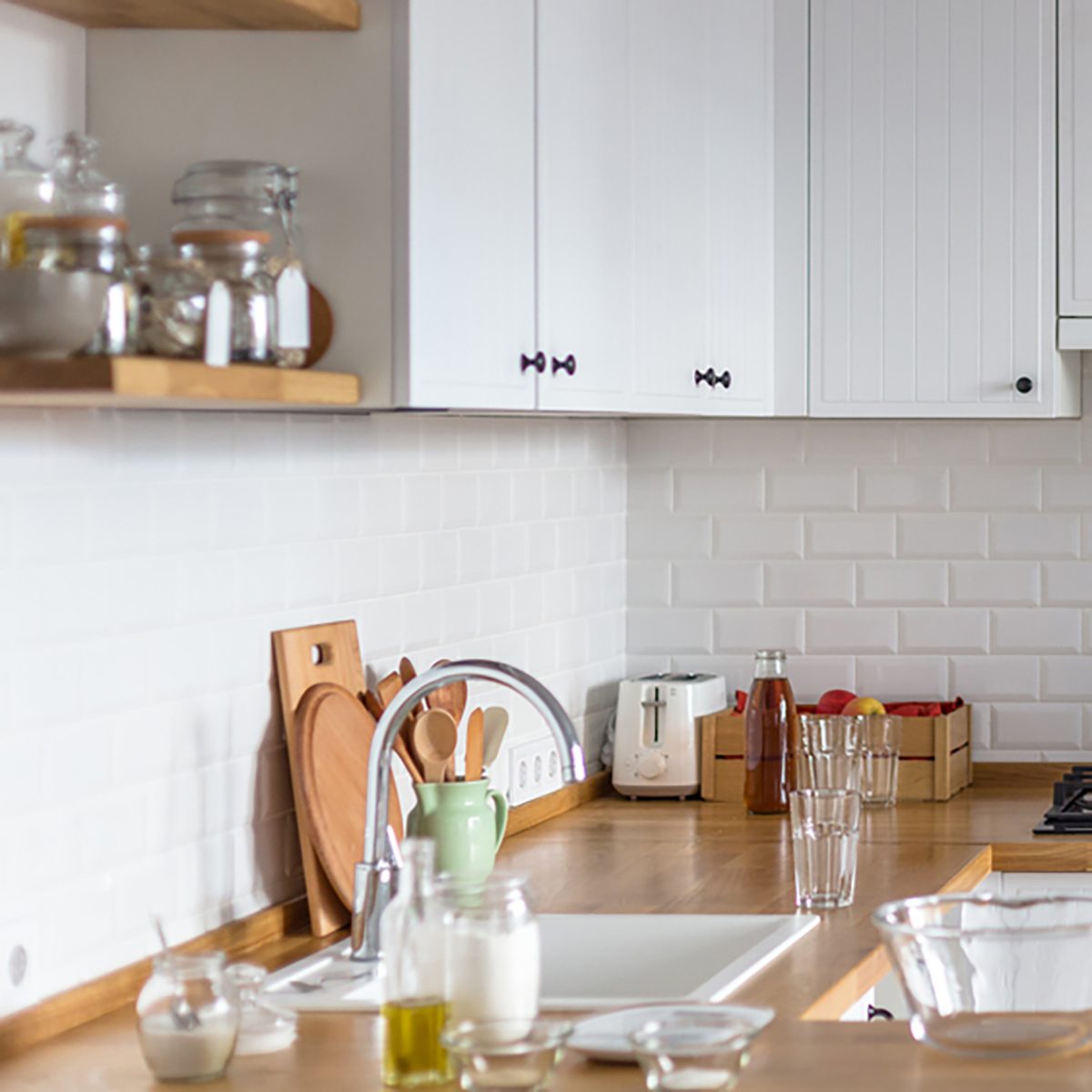 Baking ingredients placed on wooden table, ready for cooking. Concept of food preparation, white kitchen on background.