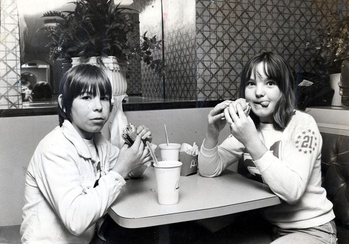 Two children eating hamburgers in McDonalds
