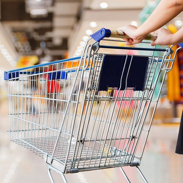 woman pushing shopping cart in shopping mall;