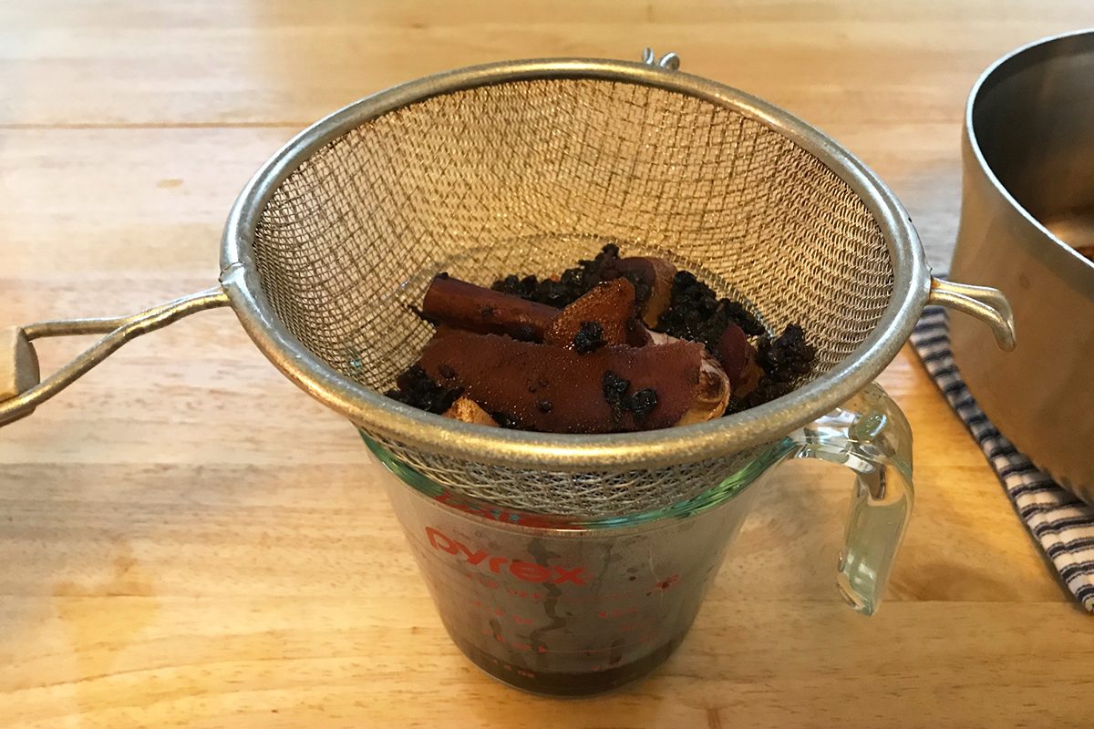 straining solids from elderberry syrup