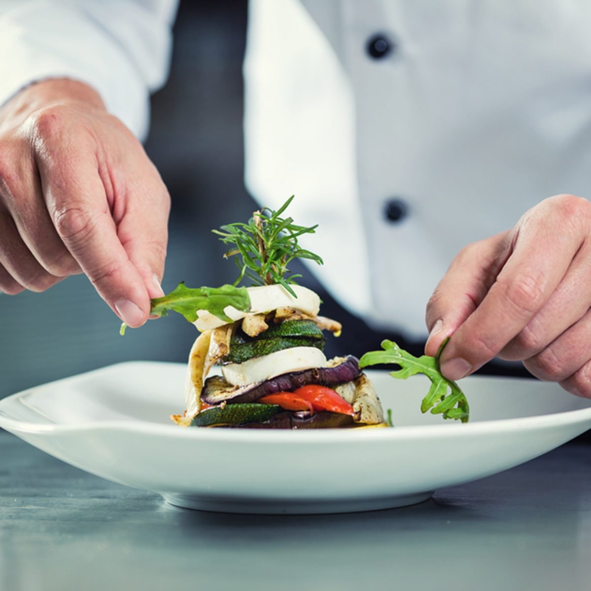 Chef in Restaurant garnishing vegetable dish