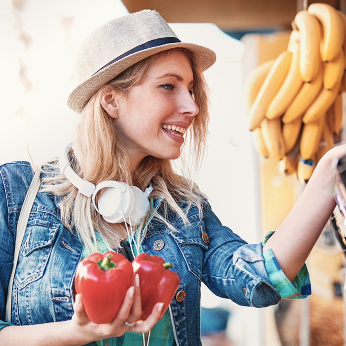 Young woman is looking for paprika at green market.
