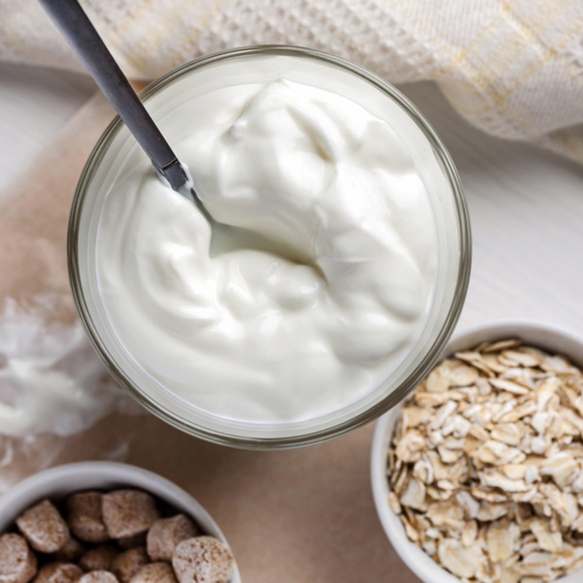 Yogurt with wheat bran and oat flakes on a wooden table
