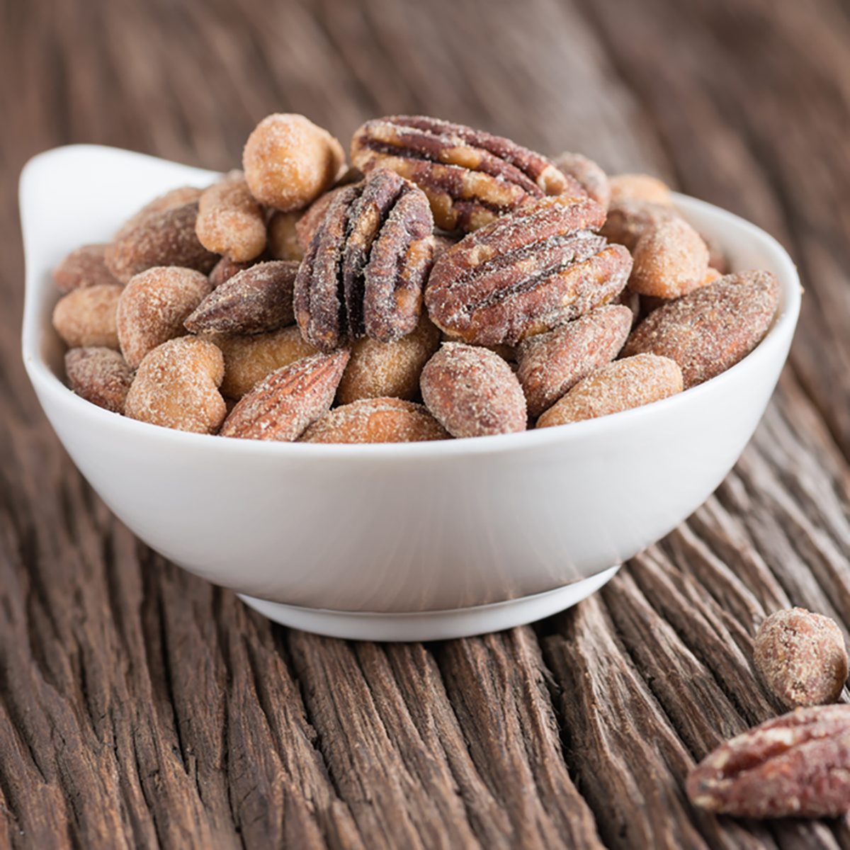 Honey roasted mixed nuts with honey on wooden table