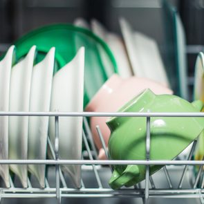 Open dishwasher with clean glass and dishes