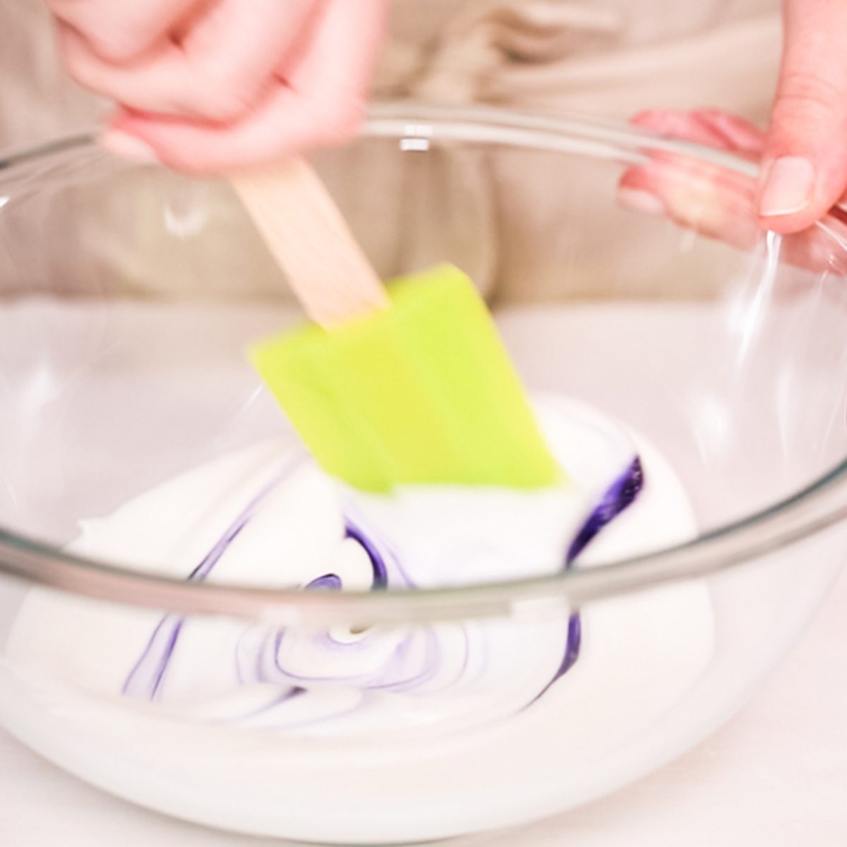 Mixing food coloring into royal icing to decorate unicorn sugar cookies.