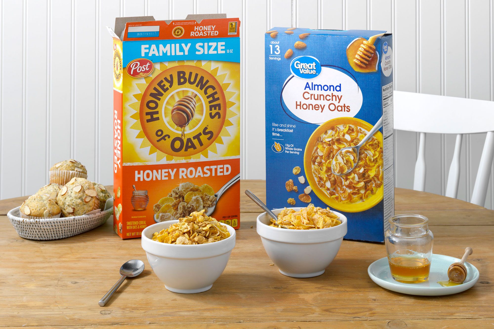 Post's Honey Bunches of Oats with Crispy Almonds and Walmart's Great Value Almond Crunchy Honey Oats on a table with honey and muffins