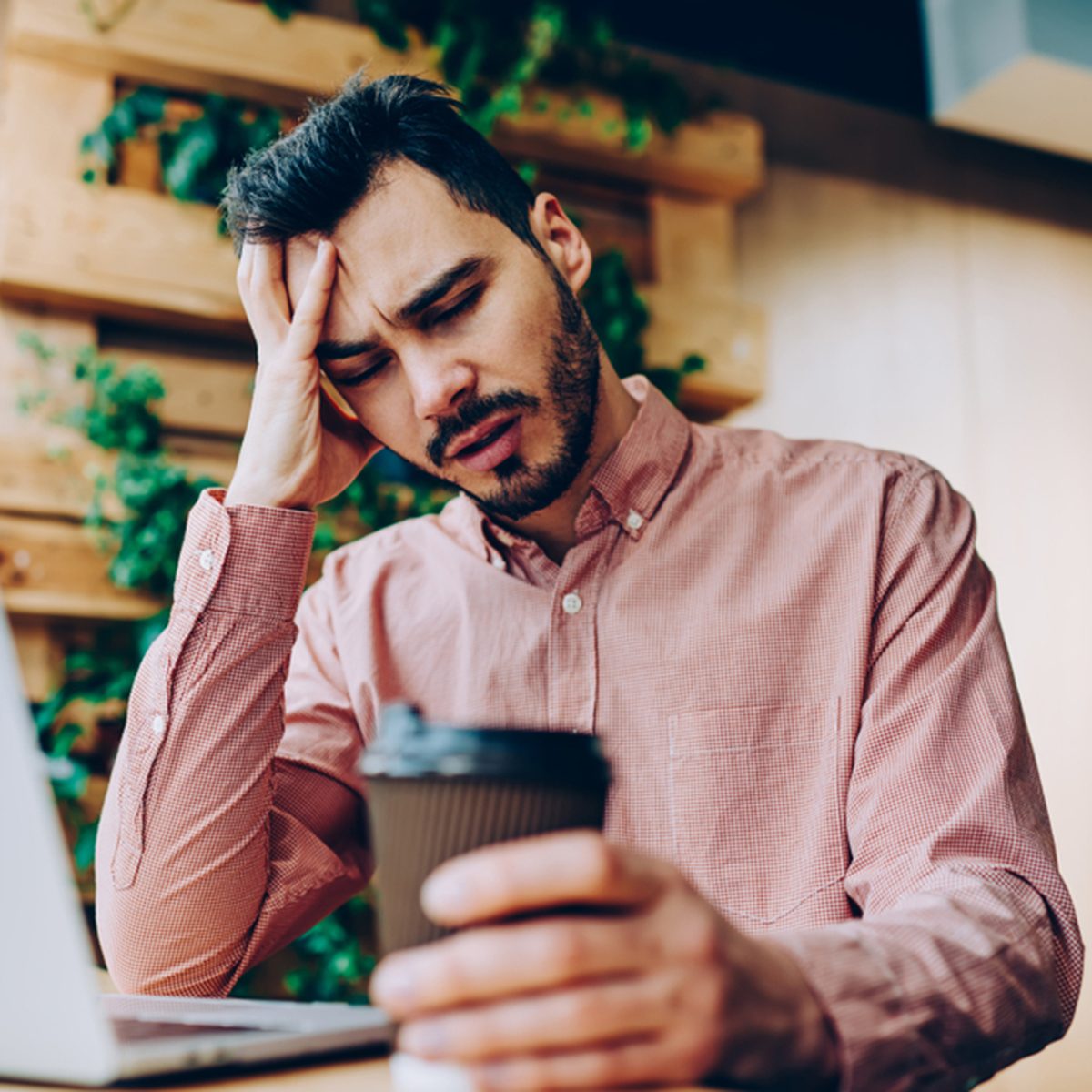 Tired sad male student with closed eyes upset with education problems preparing for exams
