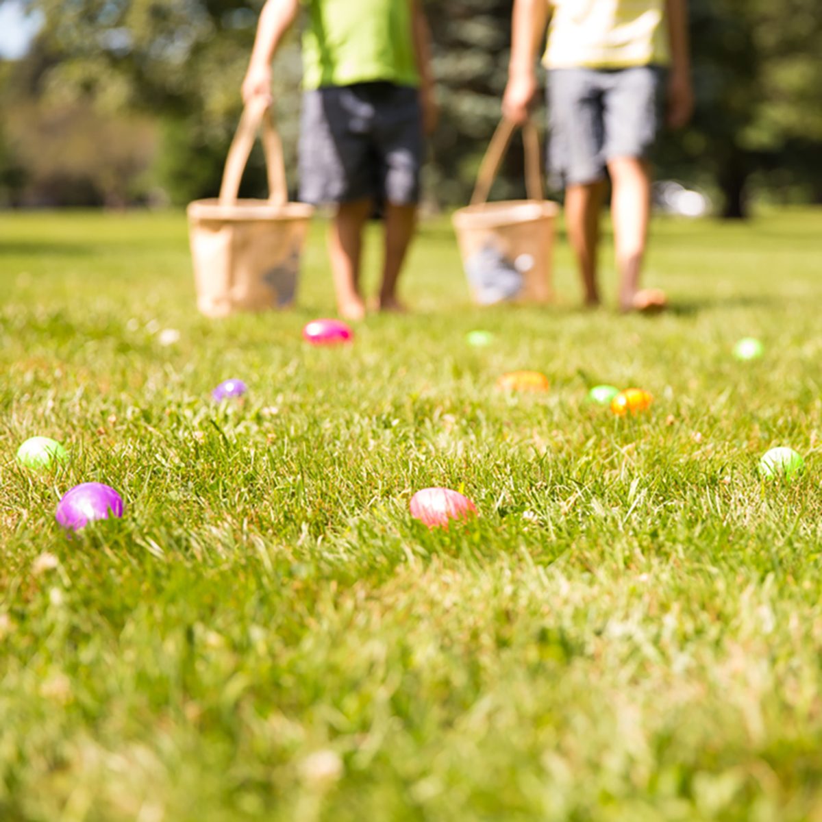 easter eggs hunt. Blurred silhouettes of children with baskets in hands.