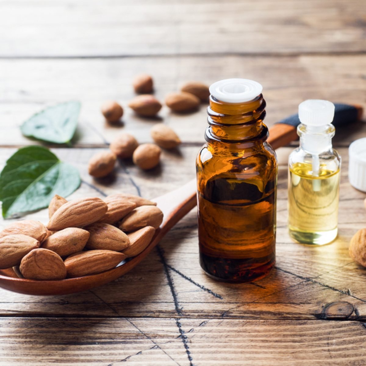 Almond oil in bottle on wooden background. 