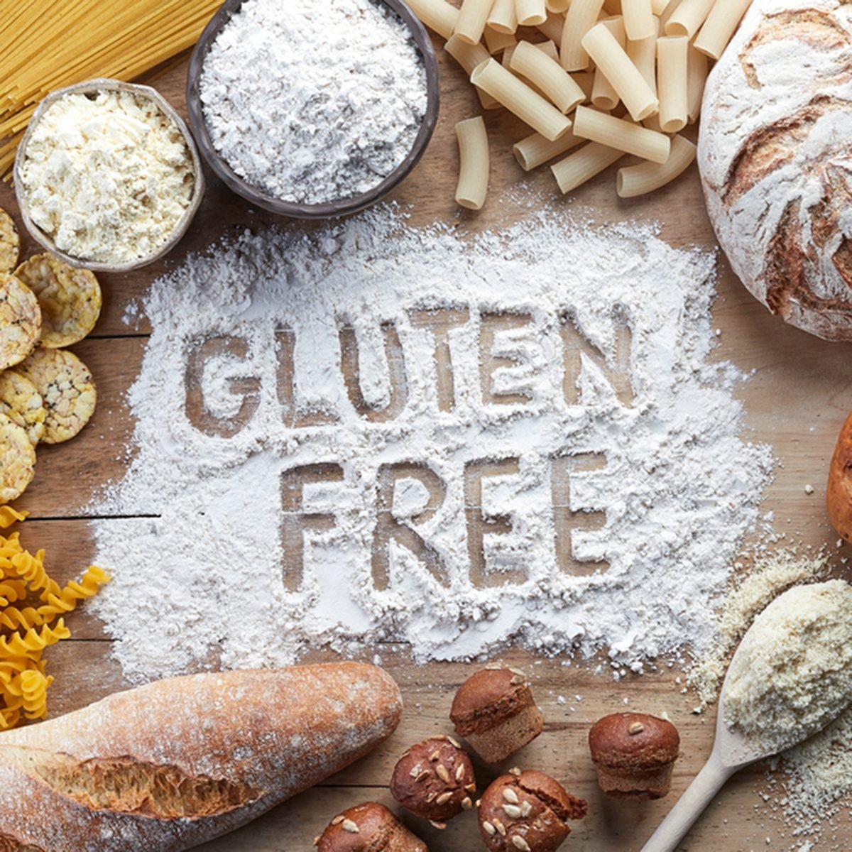 Gluten free food. Various pasta, bread, snacks and flour on wooden background from top view