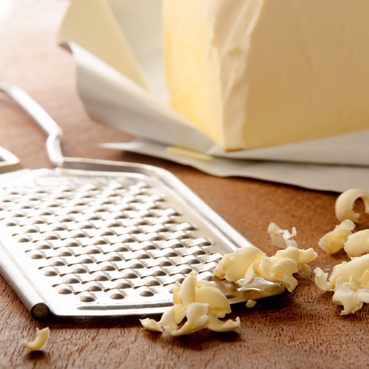 grated butter and grater on wooden board