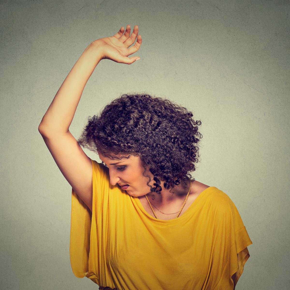 Closeup portrait young woman, smelling, sniffing her wet armpit