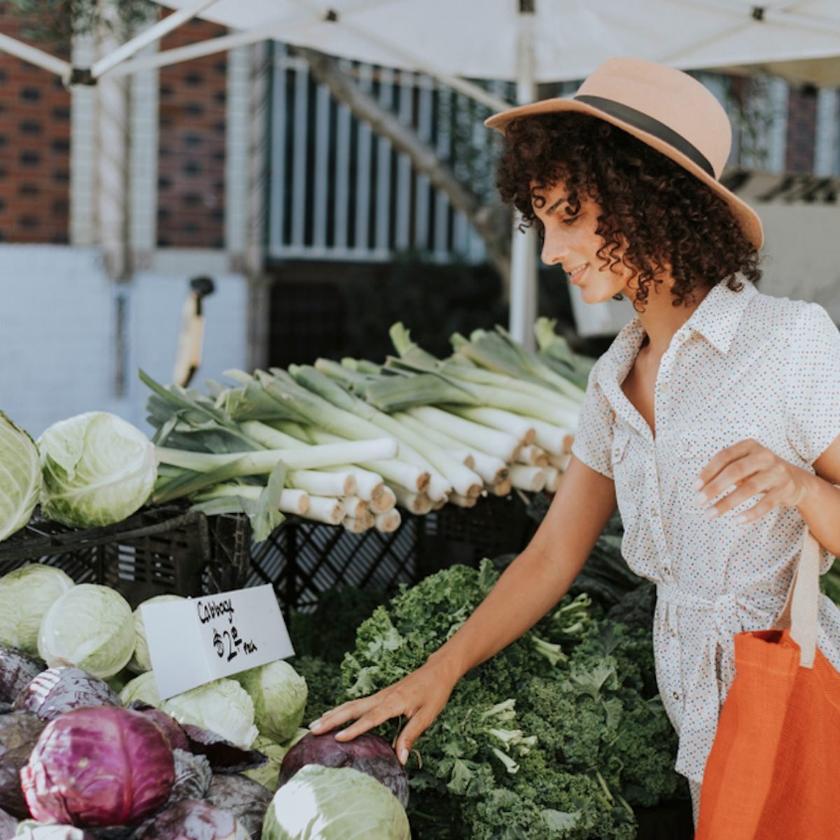 Beautiful woman buying vegetables at a farmers market