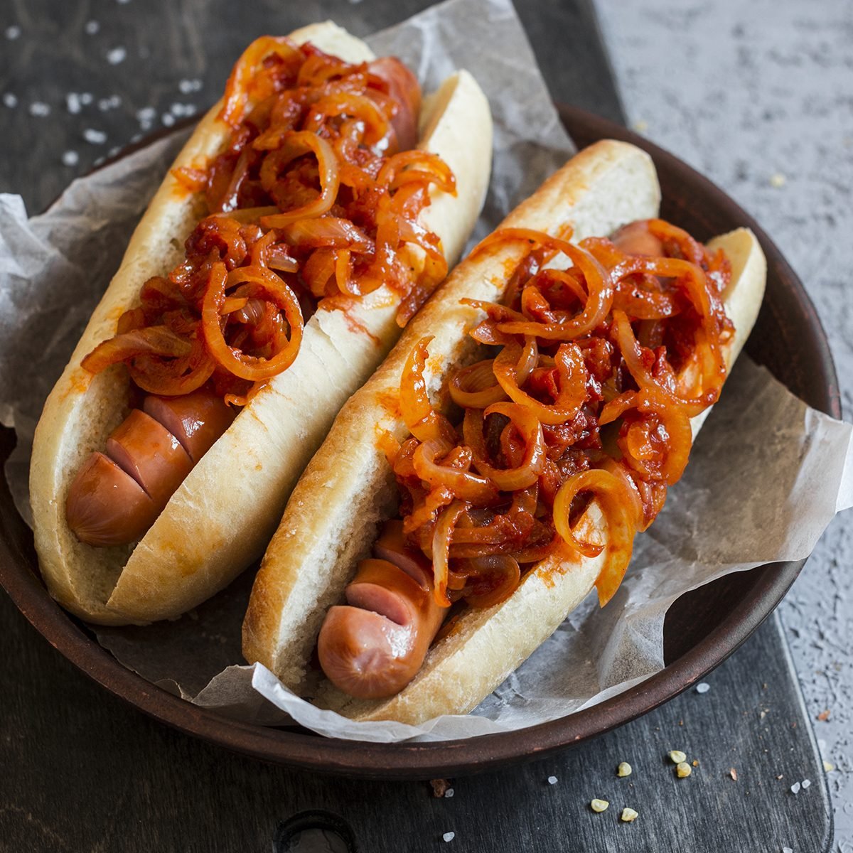 Hot dog with New York street style tomato onion sauce on a wooden background