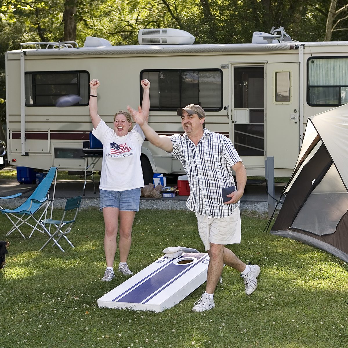 Husband and wife playing cornhole beanbag toss game at Mounds State Park in Anderson, Indiana.