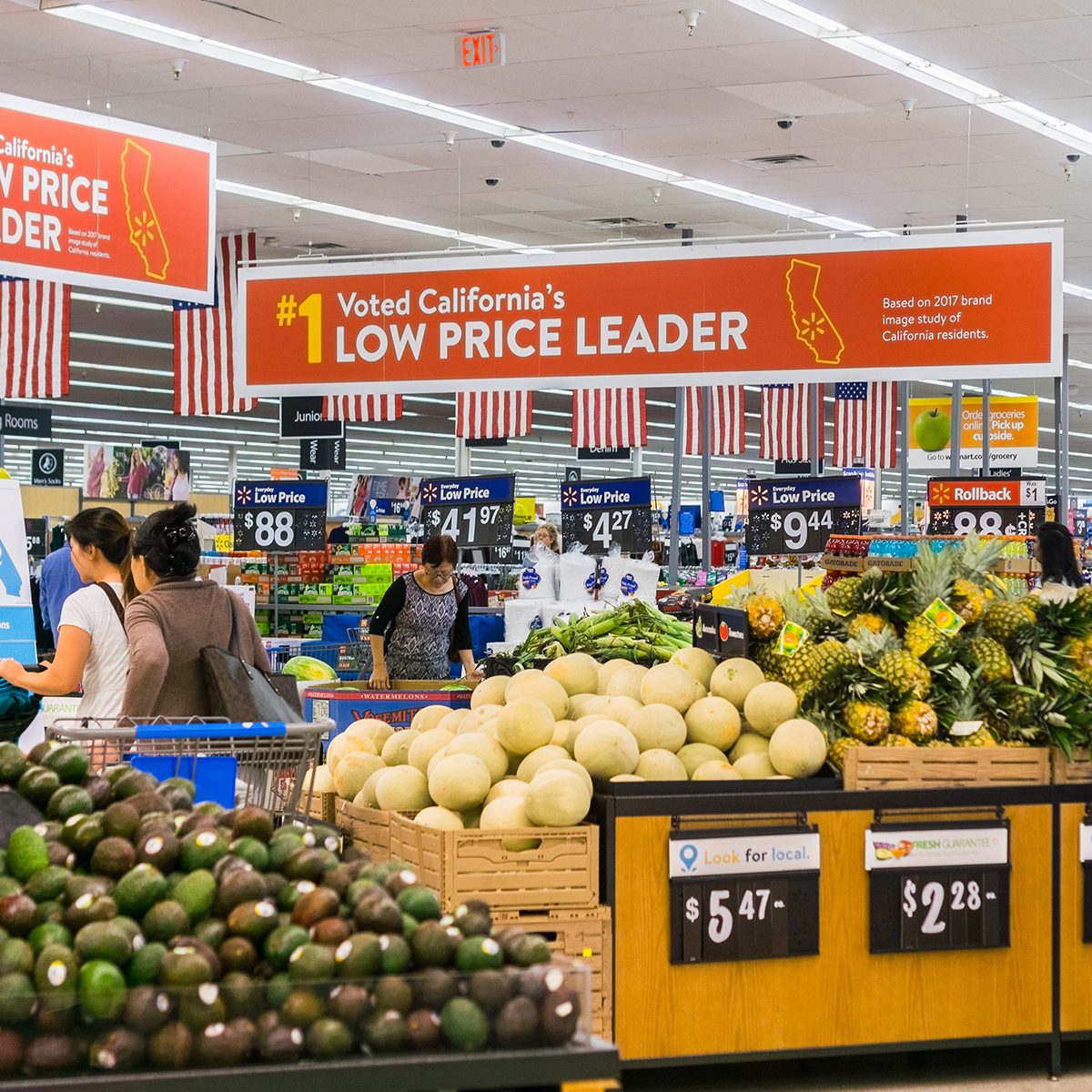 People shopping in the food and vegetable area of one of Walmart