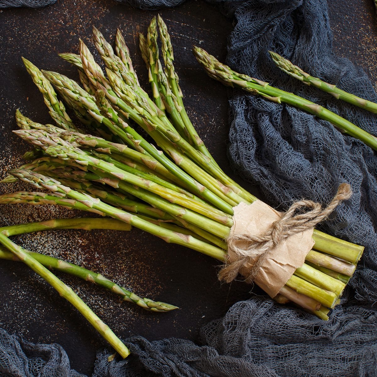 Fresh raw asparagus spears on a dark table